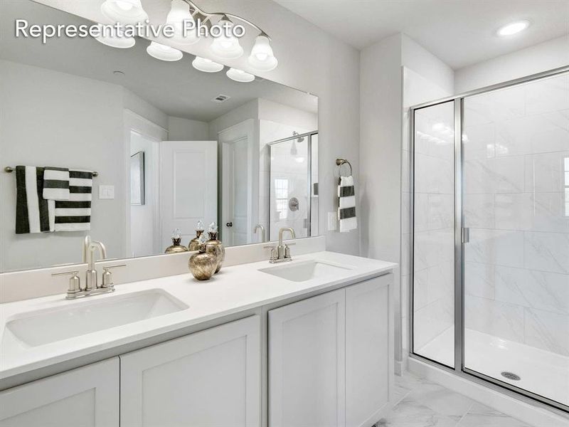 Bathroom with double vanity, walk in shower, and tile patterned floors