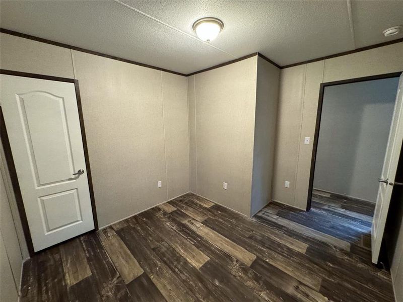 Unfurnished bedroom with dark hardwood / wood-style floors and a textured ceiling