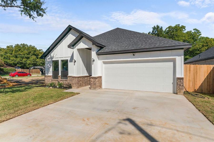 View of front of home with a front lawn and a garage