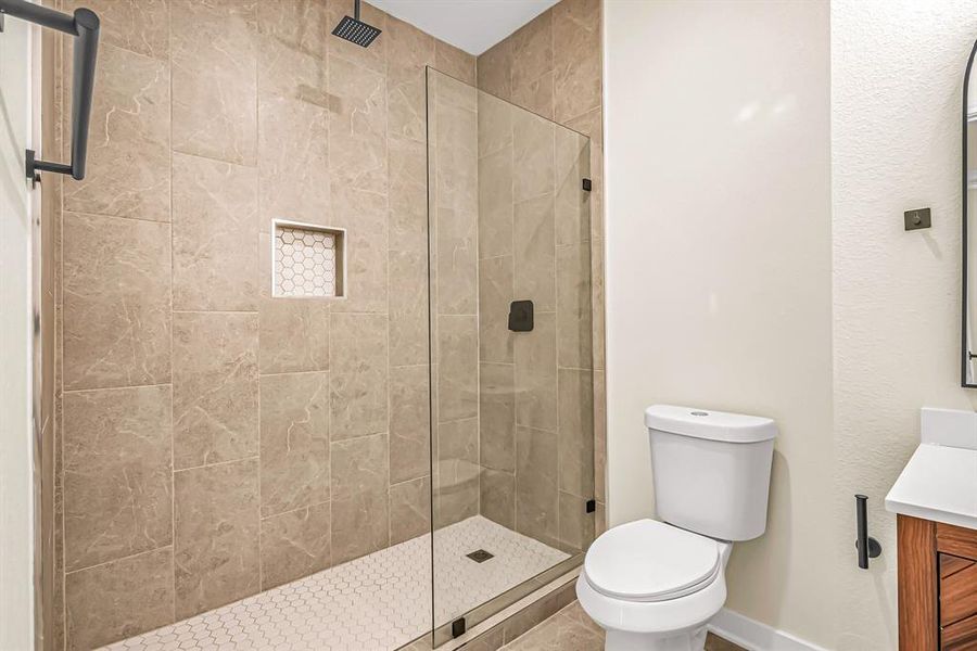 Guest bath with seamless glass shower panel and tile inset.