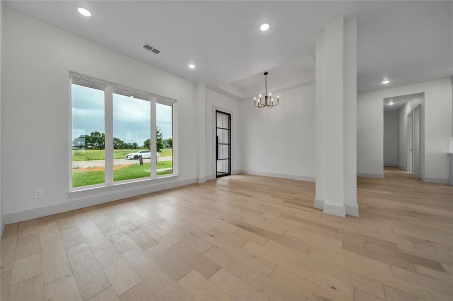 Unfurnished living room with light hardwood / wood-style flooring and a chandelier