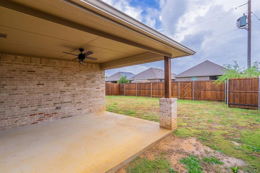 View of yard featuring ceiling fan and a patio