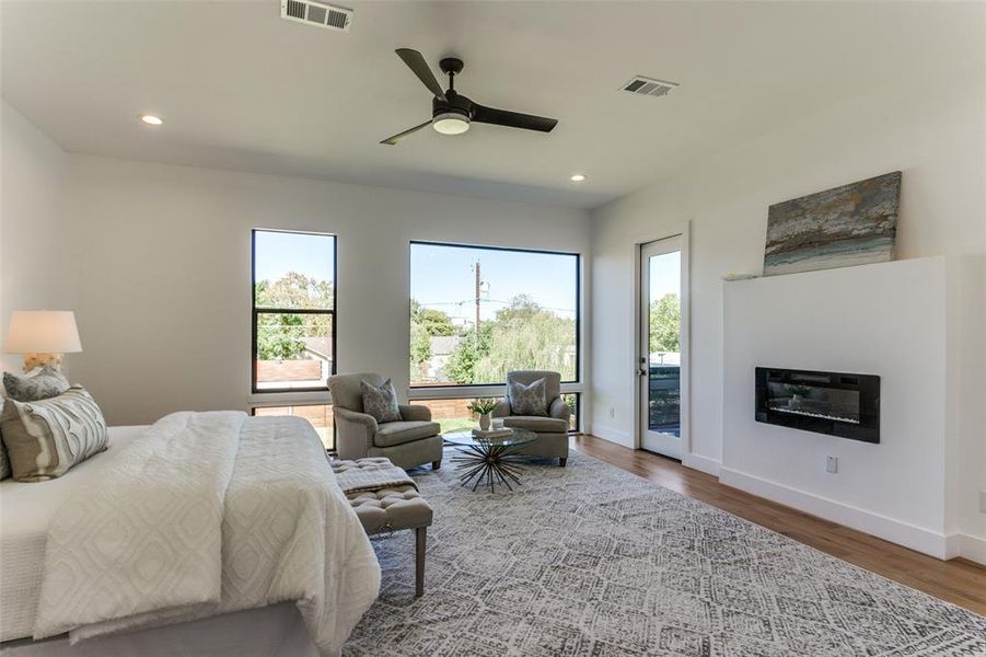 Bedroom featuring ceiling fan, access to outside, multiple windows, and hardwood / wood-style floors