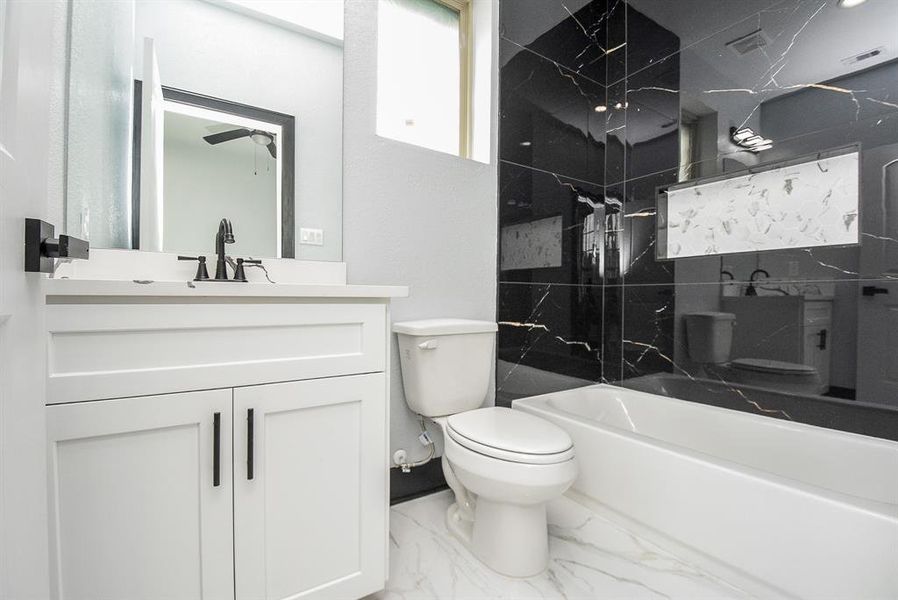 Full bath with a tub-shower combo and quartz countertop, serving one room.