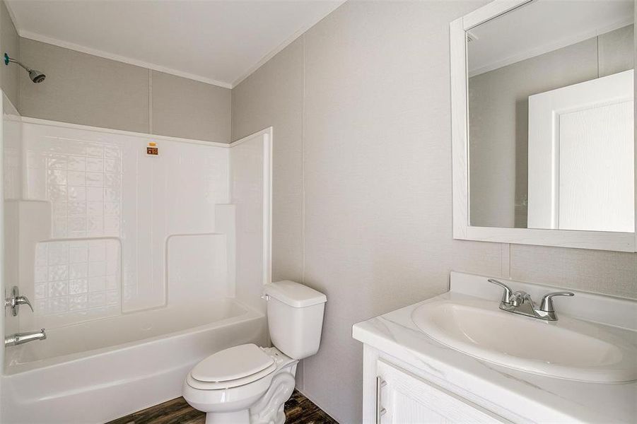 Full bathroom with vanity, hardwood / wood-style floors, toilet, ornamental molding, and  shower combination