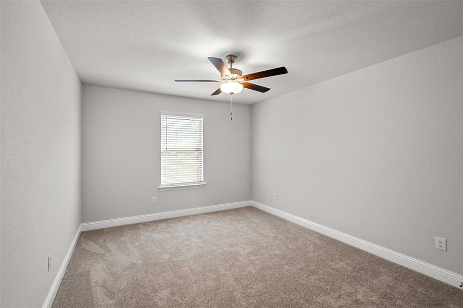 Spare room featuring ceiling fan, carpet floors, and a textured ceiling