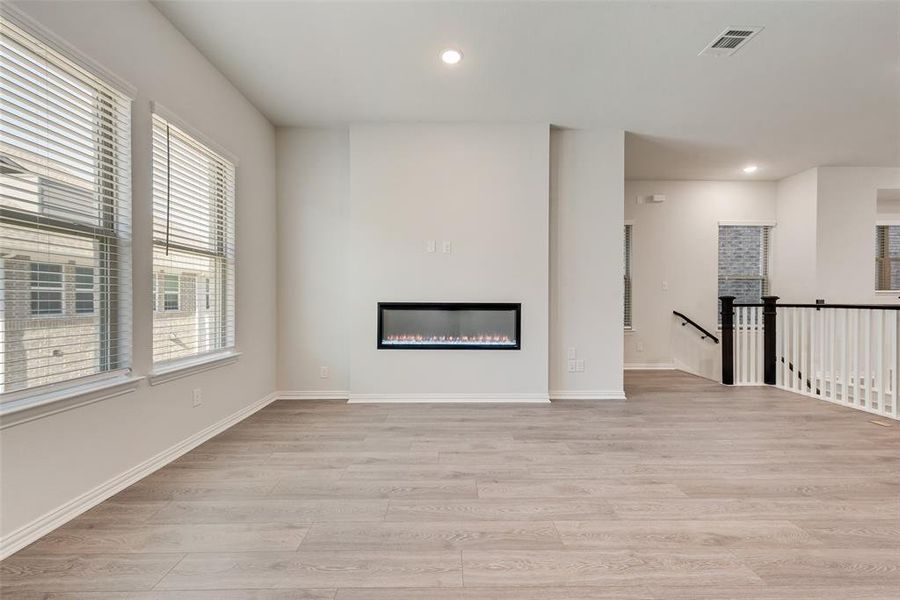 Unfurnished living room featuring light wood-type flooring and plenty of natural light