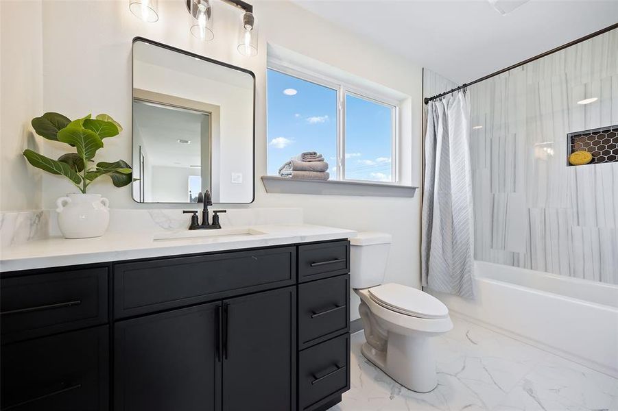 Full bathroom with toilet, shower / bath combo with shower curtain, and vanity