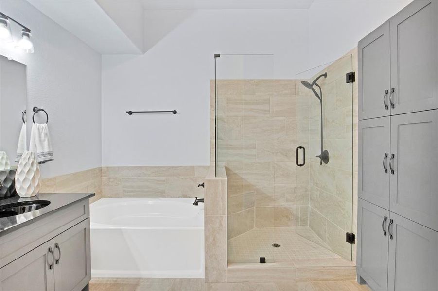 Primary bathroom with a large walk-in shower with built-in seat, a soaking garden tub, and built-in cabinets providing tons of extra storage space.