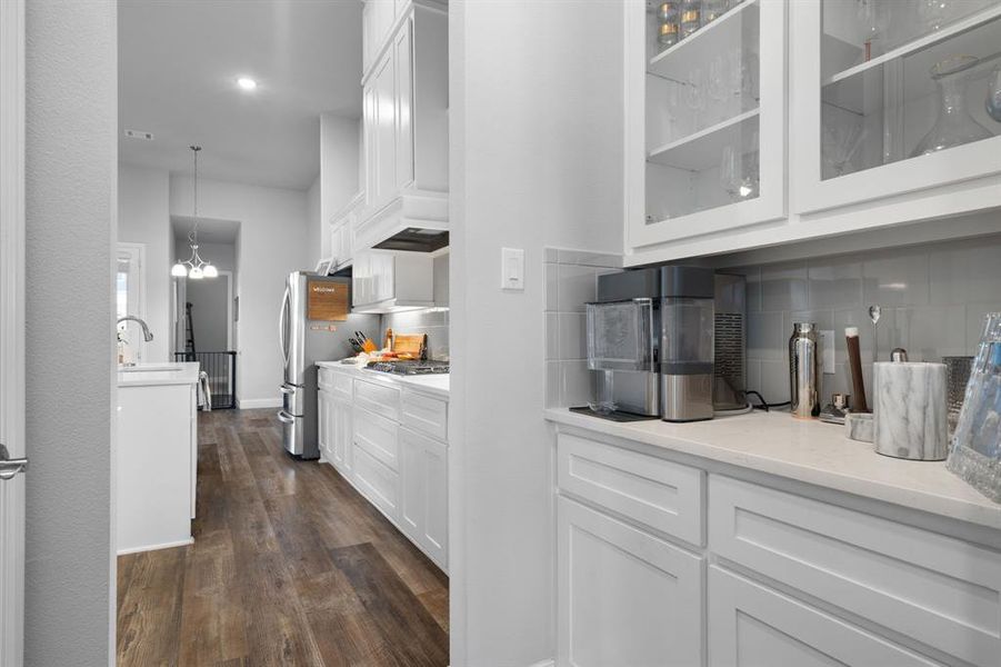 Butler's pantry with additional countertop space and glass front cabinets