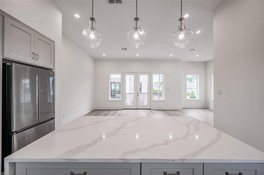 View from the open concept kitchen looking onto the living area with French Doors opening to the balcony.