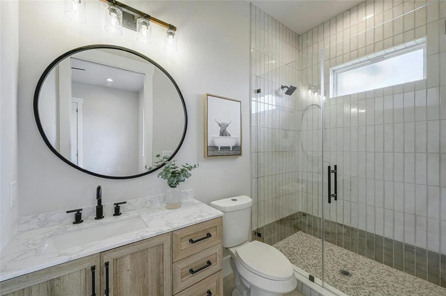 On-suite guest bathroom featuring custom floor to ceiling glass and ceramic tile work with frameless shower glass enclosure.