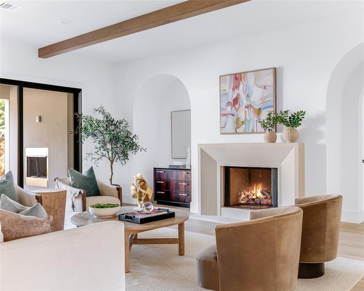 Living room with beamed ceiling and light hardwood / wood-style flooring