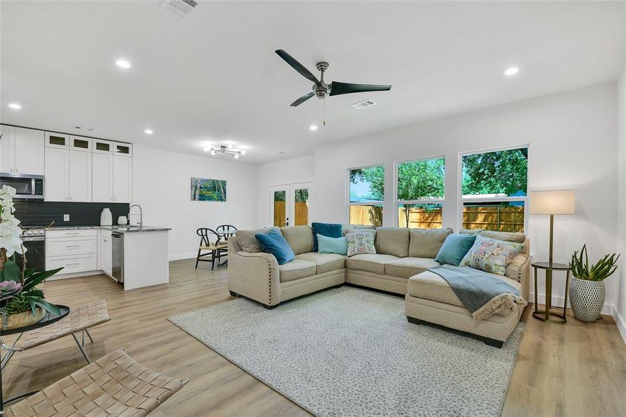 Living room with ceiling fan, light hardwood / wood-style flooring, and sink