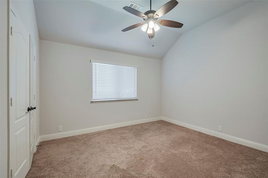 Unfurnished room with lofted ceiling, carpet, and ceiling fan