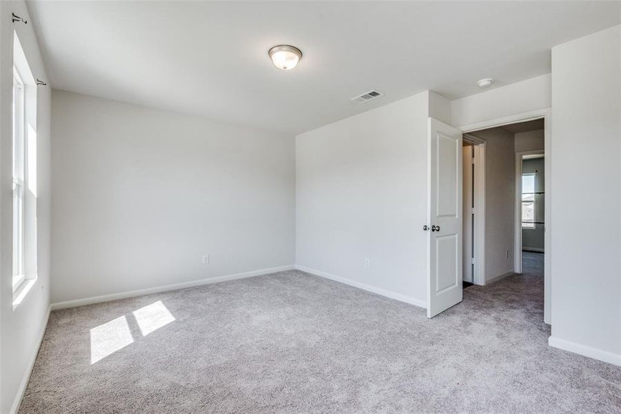 Carpeted empty room featuring a wealth of natural light