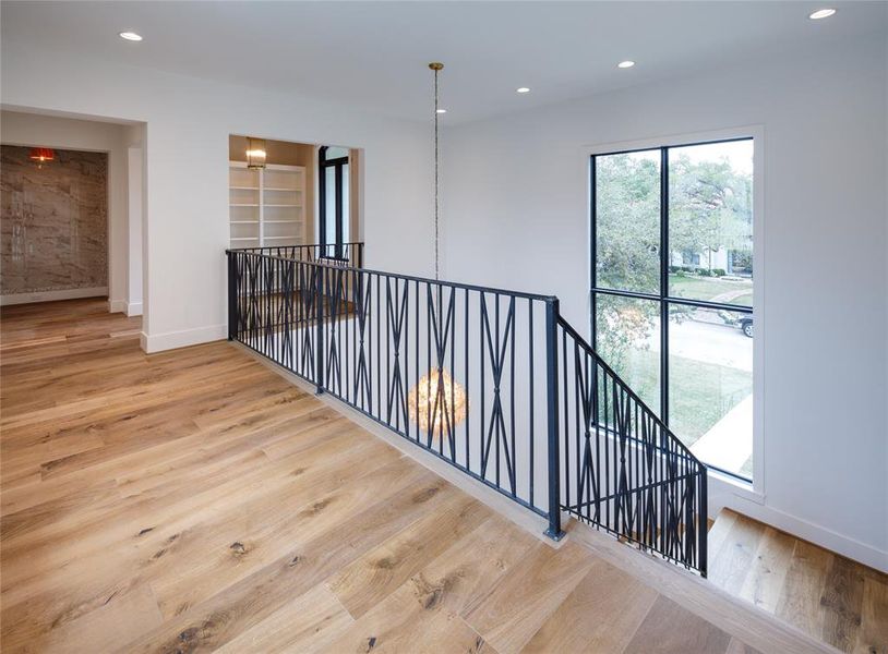 Second floor landing with Engineered French Oak wood floors and tall stair windows with front yard views