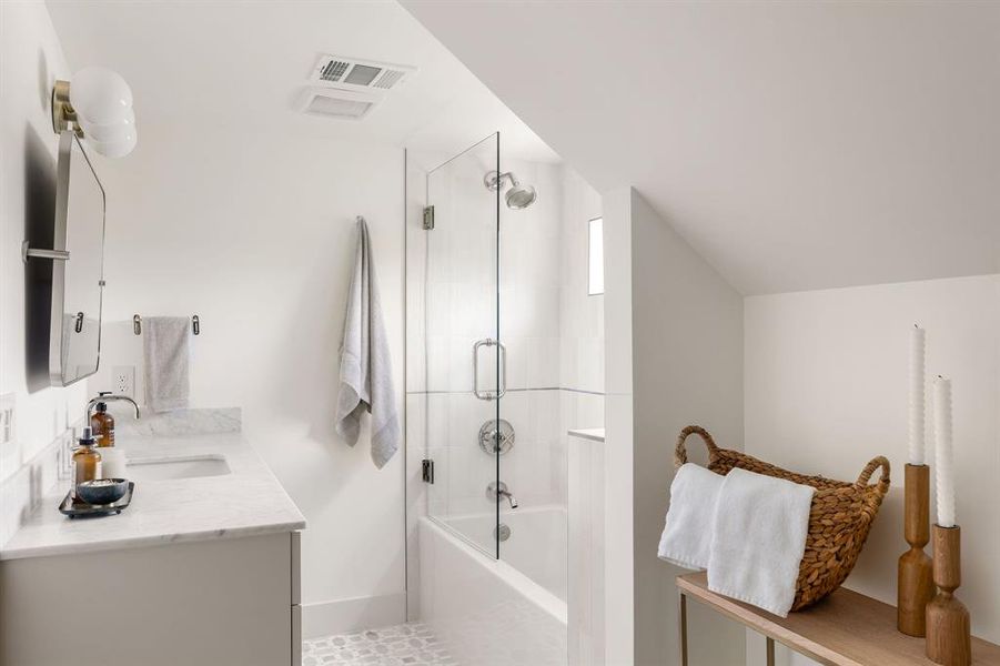 Third level/studio bath features marble countertops and matte ceramic tile. The attention to detail truly is found throughout this home.