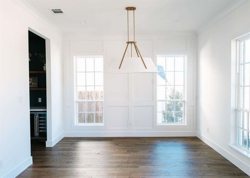 Unfurnished dining area featuring ornamental molding, dark hardwood / wood-style floors, and a healthy amount of sunlight