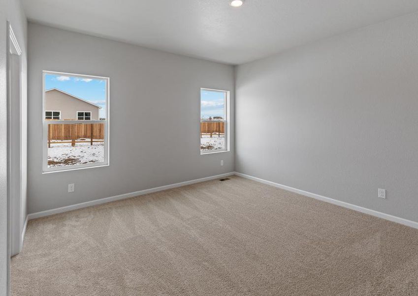 Master bedroom with two windows and an attached bathroom.