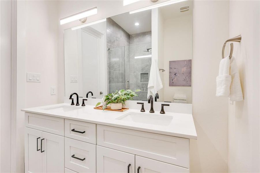 Bathroom featuring a shower with door and vanity