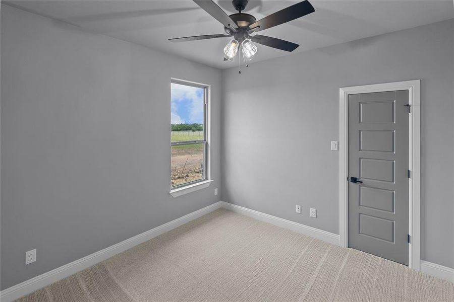 Carpeted empty room featuring ceiling fan