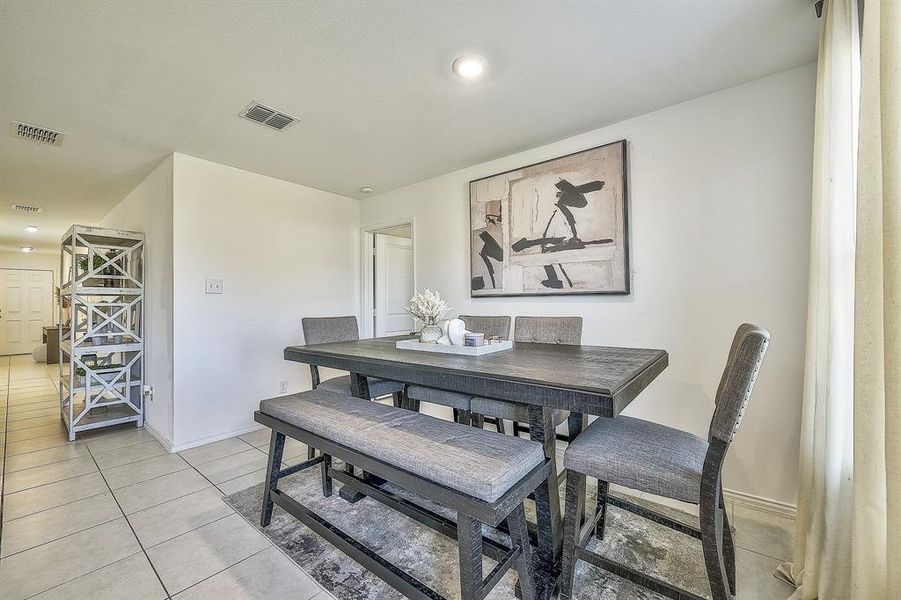 Dining space with light tile patterned flooring