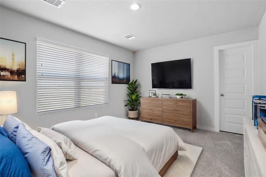 This secondary bedroom features custom paint, plush carpet, and a large window with privacy blinds!