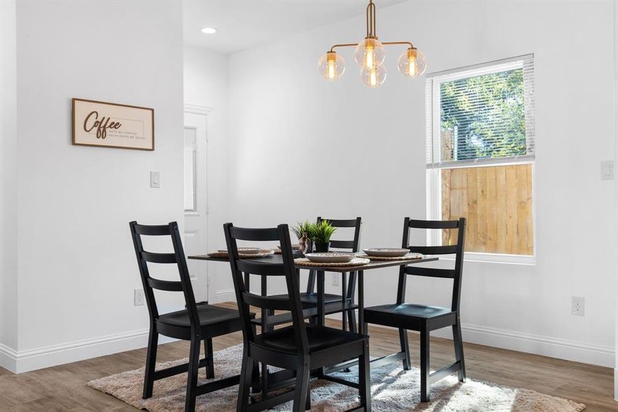 Dining space with hardwood / wood-style flooring and a notable chandelier