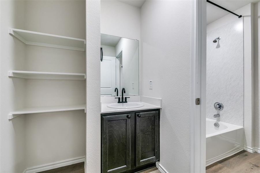 Bathroom featuring vanity, hardwood / wood-style floors, and shower / washtub combination