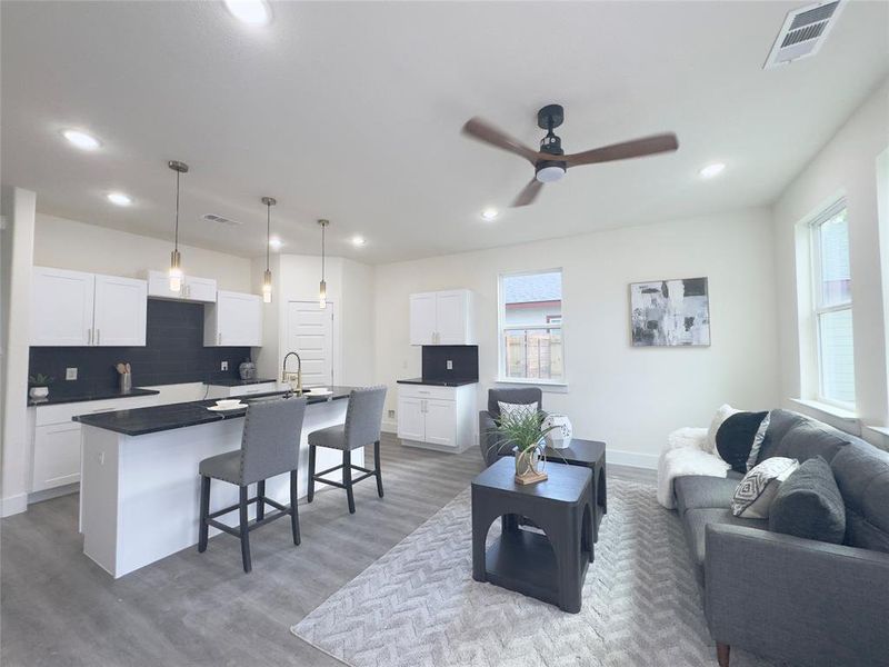 Living room featuring sink, ceiling fan, and light hardwood / wood-style floors