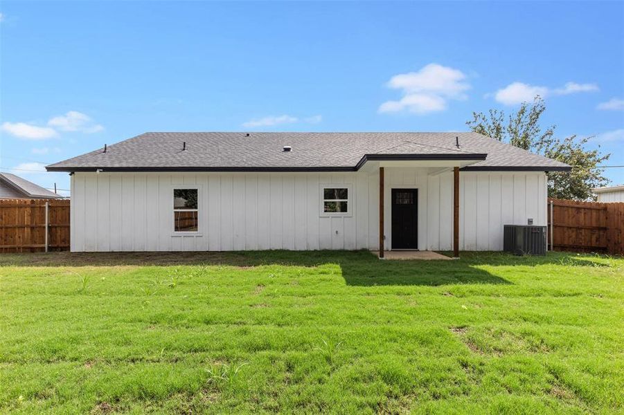 Rear view of property with a yard