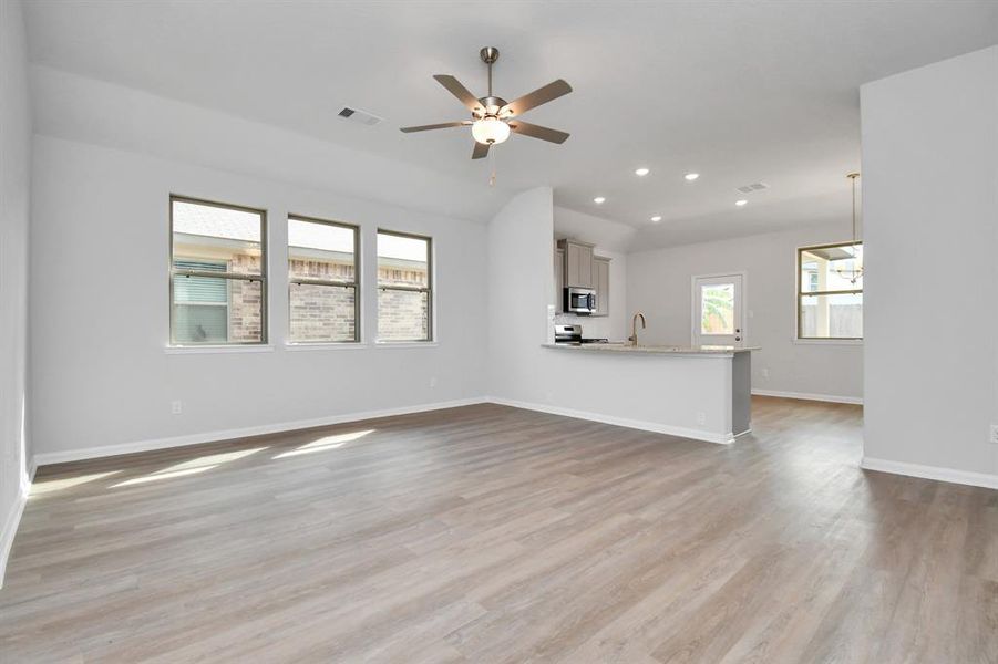 Gather your loved ones and guests in this spacious family room features an open layout that flows effortlessly into the kitchen, creating a cohesive living space perfect for gatherings and relaxation.