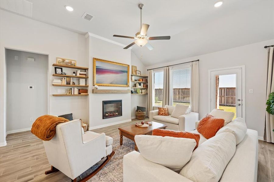 Living room with wood tile flooring, ceiling fan and electric fireplace