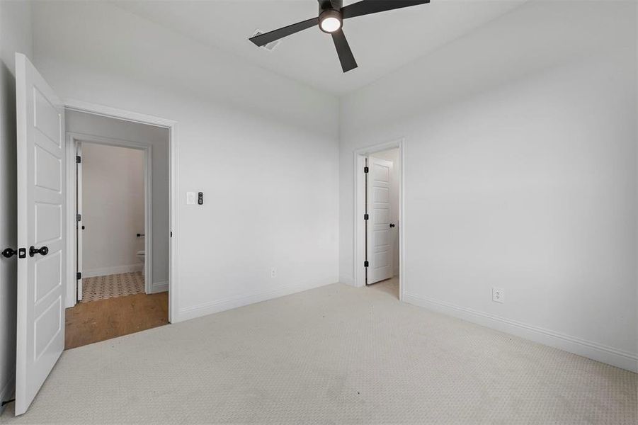 Unfurnished bedroom with ceiling fan and carpet floors