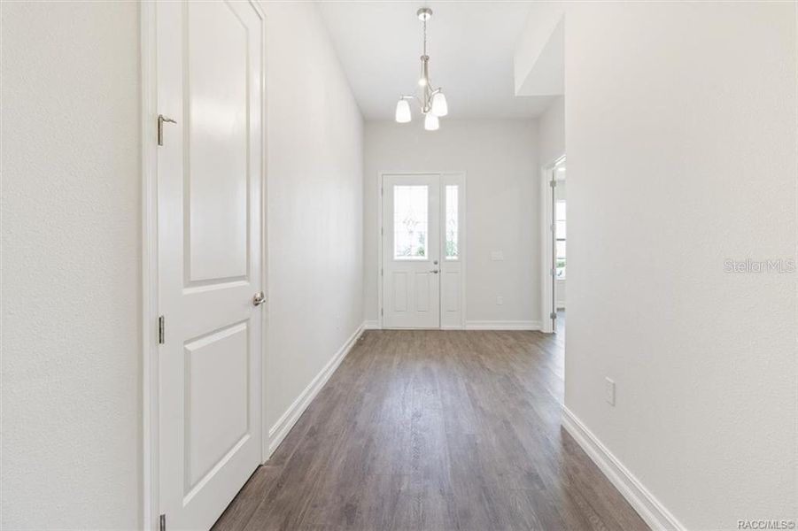 Hallway facing front entrance has coat closet