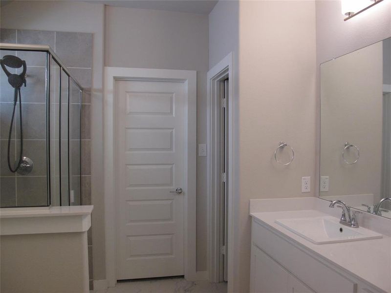 Bathroom with vanity and a shower with door