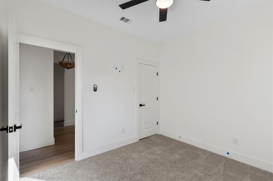 Carpeted empty room featuring ceiling fan