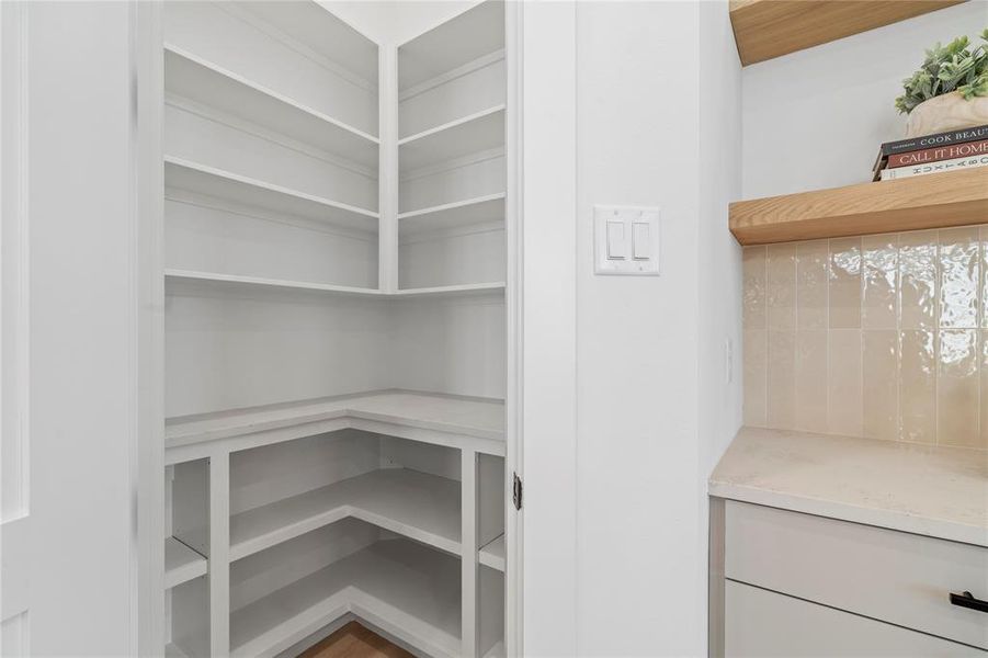 This walk-in pantry offers ample shelving and counter space, providing the perfect solution for keeping your kitchen essentials neatly organized. With its efficient design and abundant storage, you'll have everything you need at your fingertips, making meal prep and storage both simple and stylish.