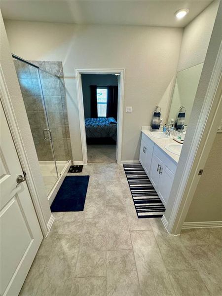 Bathroom featuring vanity, an enclosed shower, and tile patterned floors