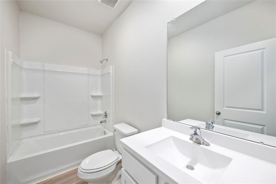 The secondary bathroom, located centrally in the hallway of the home.