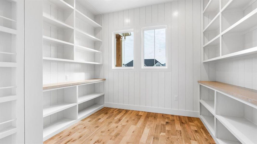 Spacious closet with light hardwood / wood-style flooring