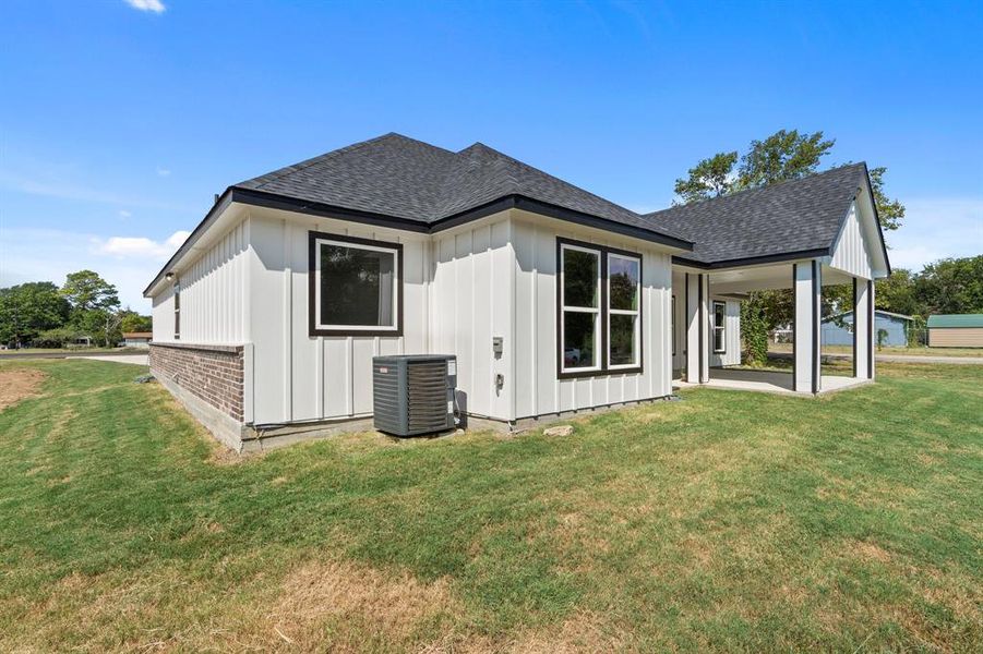 Rear view of property with cooling unit, a lawn, and a patio