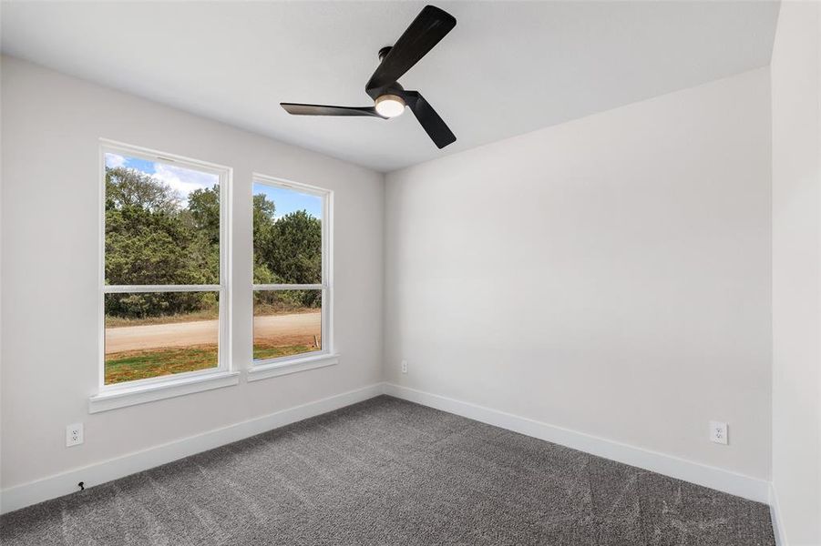 Empty room featuring ceiling fan and carpet floors