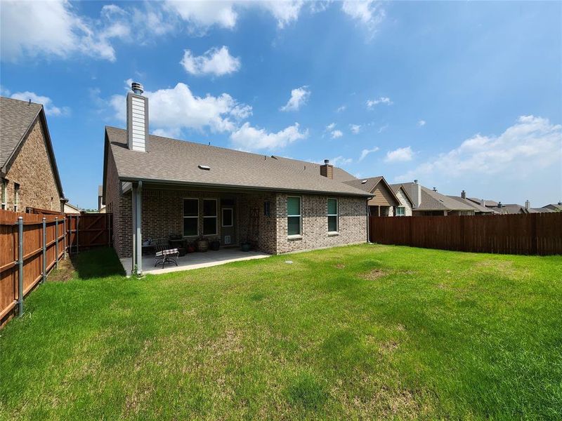 Rear view of house with a yard and a patio