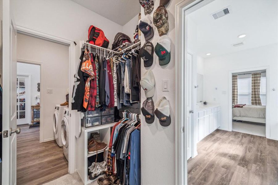 The spacious primary closet offers plenty of storage and connects directly to the utility room, providing incredible convenience for laundry access. This smart design also allows easy access to the main entryway, making daily routines a breeze—a truly unique and thoughtful feature of this floor plan!