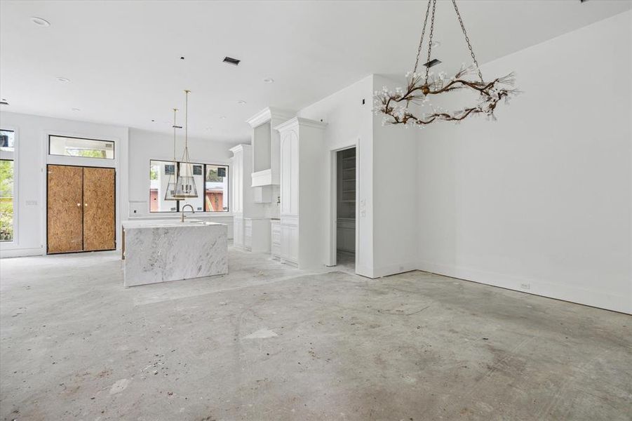 A view from the dining area toward the kitchen.  The opening to the right of the picture is an additional pantry access point with a door.  A great option to keep the "work" portion of your pantry hidden when entertaining.  Photo as of 9/3/2024