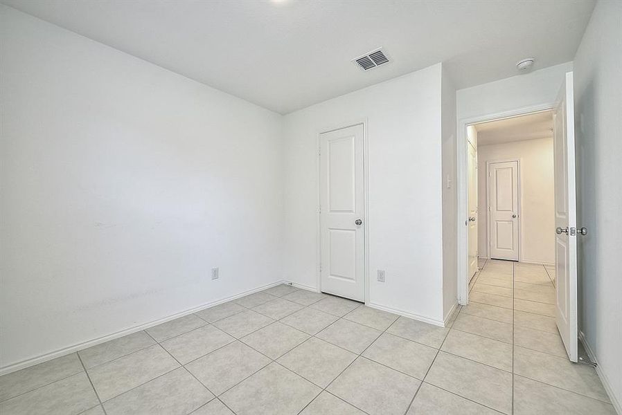 Unfurnished bedroom featuring light tile patterned floors and a closet