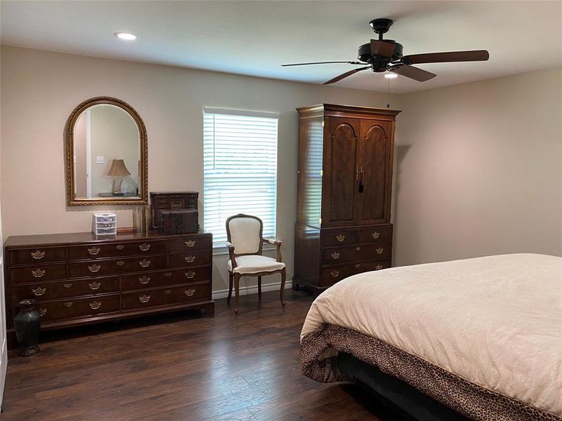 Primary Bedroom with dark hardwood / wood-style floors and ceiling fan