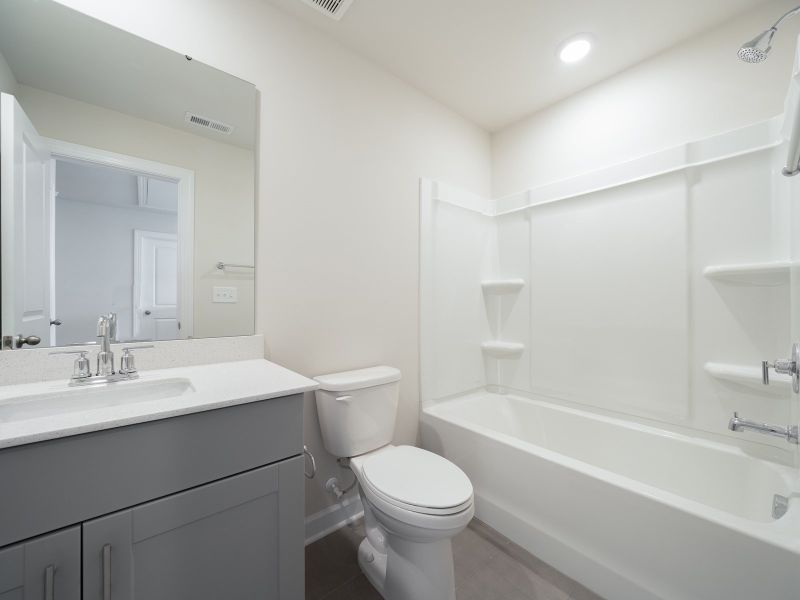 The secondary bath offers a space for guests to get ready.